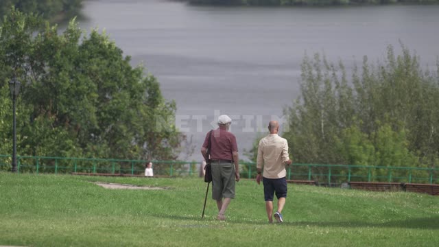 Kolomenskoye, two men go down on the grass to the embankment Kolomenskoye Museum-Reserve, Moscow...