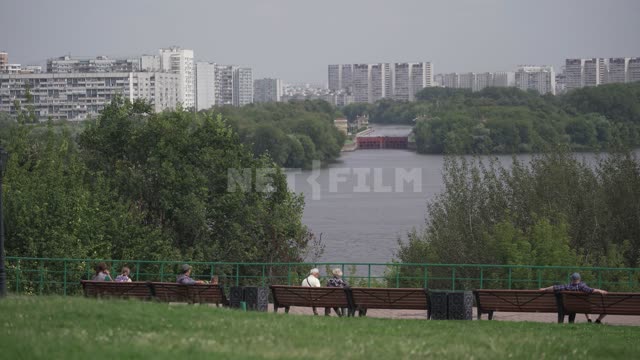 Kolomenskoye, people sit on benches on the embankment, view of the gateway and the closed...