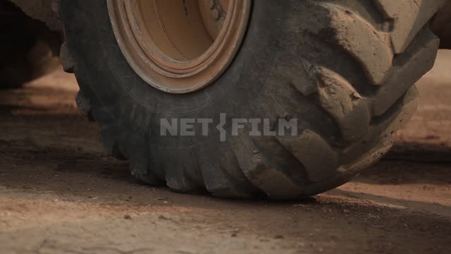 Wheels of a traveling loader, the driver in the cab Loader, road equipment, wheels, road, ground,...