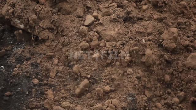Bulldozer moves the ground with stones and pieces of rebar Bulldozer, road equipment, earth, clay,...