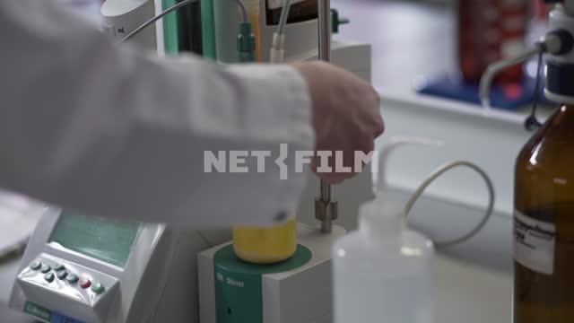The expert checks the liquid in different measuring cups Laboratory, examination, hands, measuring...