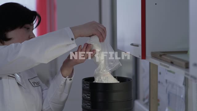 The expert pours the flour into a special canister Laboratory, examination, people, women, flour,...