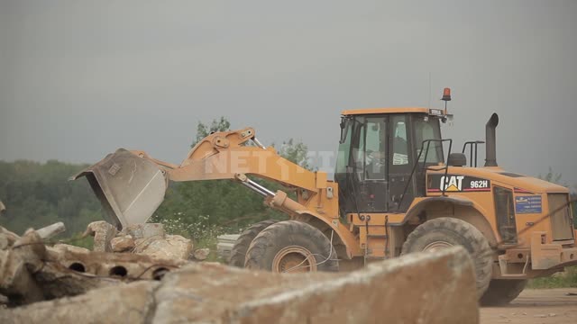 The bulldozer maneuvers on the site Bulldozer, road equipment, blockage, ruins, stones, pieces of...