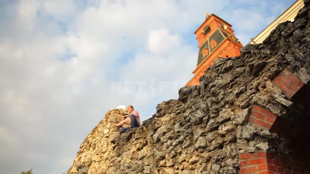 Александровский сад, грот у подножия Средней Арсенальной башни, мужчина садится на камни на крыше...