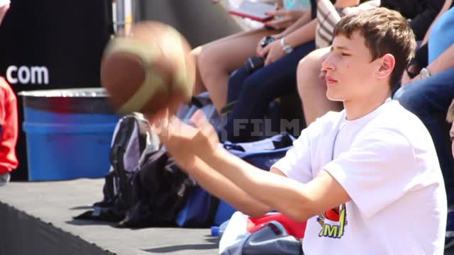 Баскетбол, юноша сидит на скамейке запасных, играет с мячом Баскетбол, мяч, люди, трибуны, рюкзаки,...