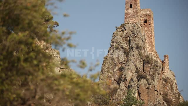Старые башни на скалах, съемка снизу вверх Горы, скалы, крепость, башни, руины, деревья, ветви,...