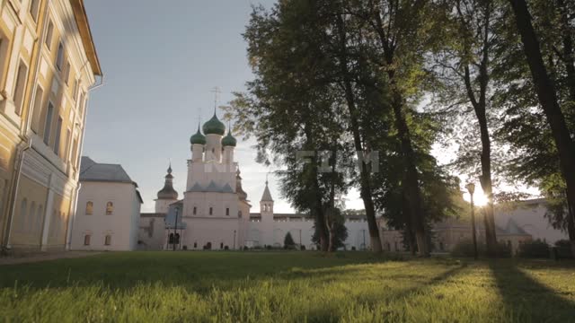 Rostov Kremlin, courtyard at sunset Courtyard, Kremlin wall, Assumption Cathedral, trees, lawn,...