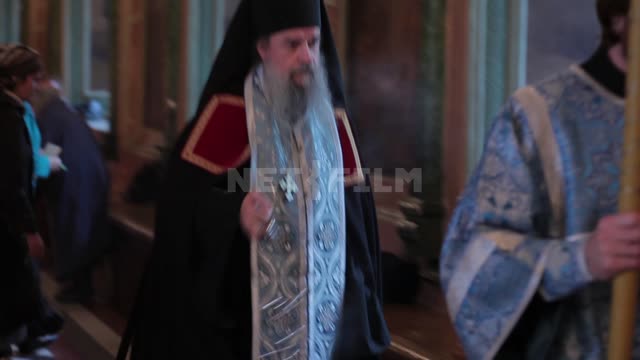 Trinity-St. Sergius Lavra, the priest walks through the hall, waving a censer, the parishioners bow...