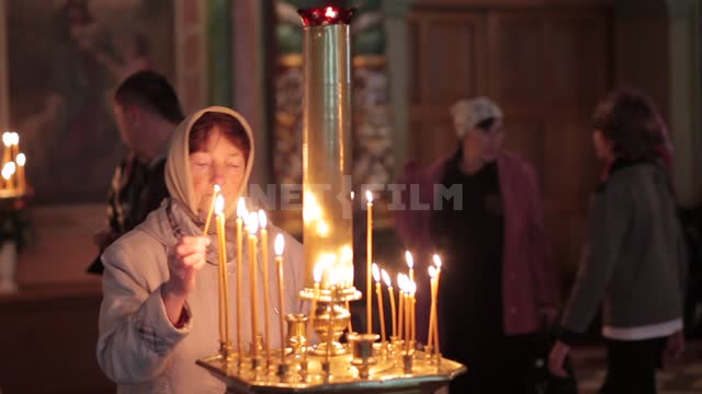Троице-Сергиева лавра, женщина зажигает свечу и ставит на алтарь Троице-Сергиева лавра,...