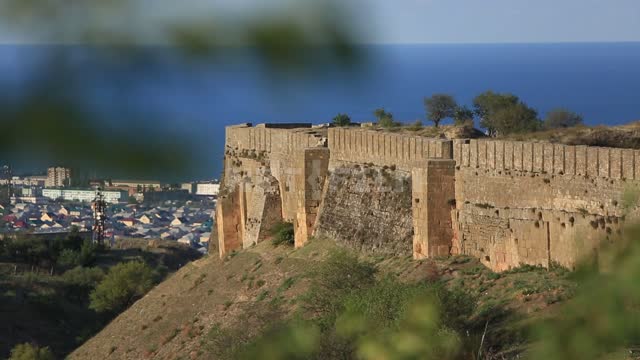 Derbent, view through the foliage of the ancient fortress, the city and the sea, change of focus...