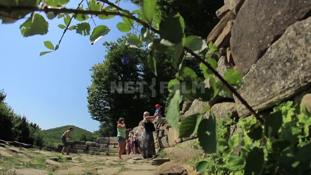 Дольмены Западного Кавказа, женщины с детьми, женщина ставит ребенка на каменную стену, съемка...
