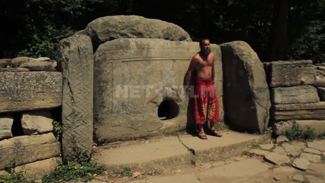 Dolmens of the Western Caucasus, a man in national trousers next to the dolmen Caucasus, dolmens,...