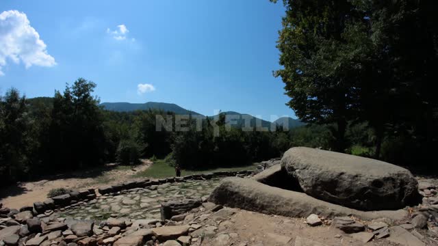 Tourists visit the Caucasian dolmens People, rocks, cobblestones, trees, sunny, mountain, timelapse