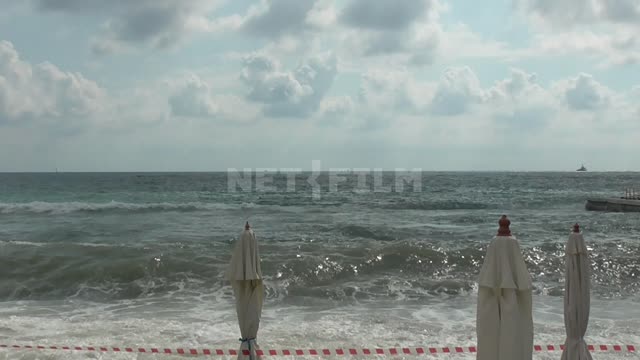 The black sea, the waves closed umbrellas on the beach Beach, black, sea, wave, tourist, holiday,...