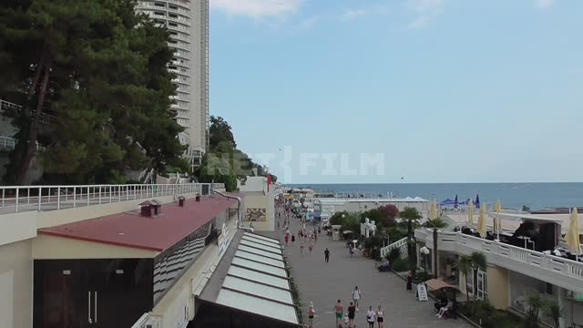 Центральная набережная города Сочи, вид сверху на черное море, по набережной гуляют люди...
