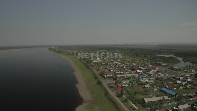 Панорама на реку, берег, поселок, дома (общий план, снято с верхней точки, с коптера). Река, поселок