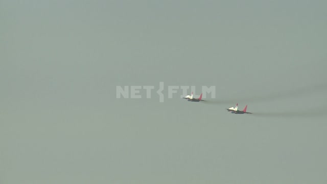 Два самолёта пилотажной группы "Стрижи" в небе показывают высшие фигуры пилотажа.Средний план....