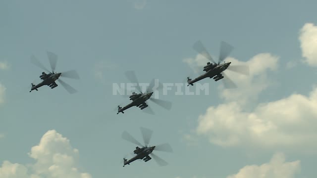 Four helicopters perform aerobatics. Military helicopters