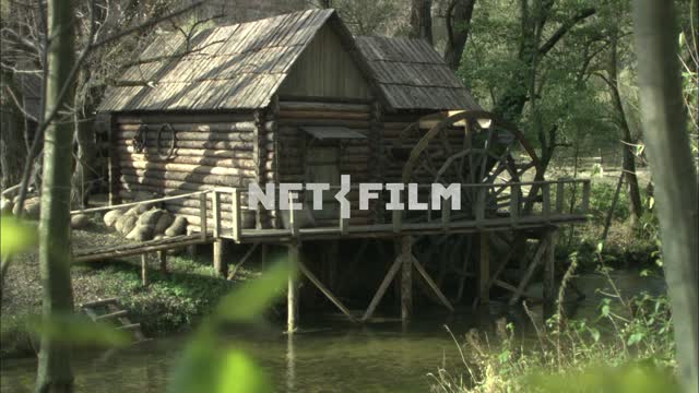 Watermill in forest by the river. Village.
River.
Wheel.
Bags the wall of the mill.
Forest.
Sunny...