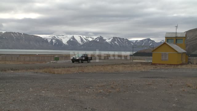 The car rides on the streets of Svalbard Russian North, mountains, snow, helicopter, driving, road,...
