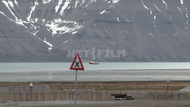 Mountain view by the sea and sailing ship. Russian North, mountains, snow, ship, traffic sign,...
