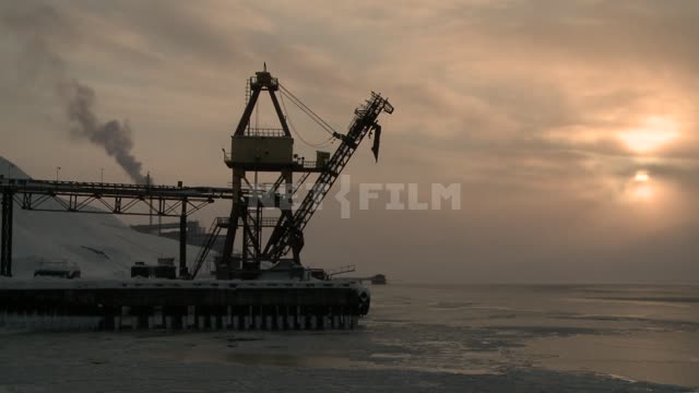 View of the pier and crane in the port. Russian North, sea, sun, clouds, clouds, port, pier, dock,...