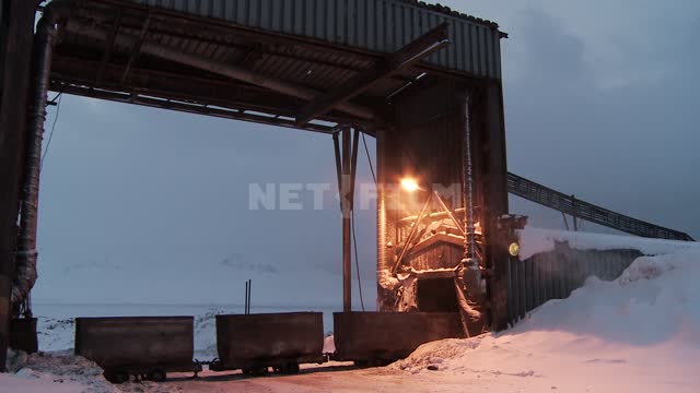 The truck and the locomotive with the composition of trolleys passing under process arch. Russian...