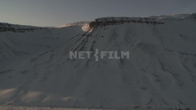 The span of a helicopter along a mountain ridge. Russian North, mountains, ridge, beach, snow,...