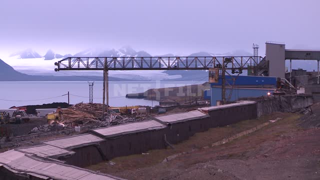 View of the port infrastructure and overhead crane. Russian North, gantry crane, logs, pipes,...