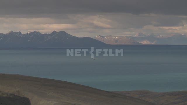 The sea and the mountains. Russian North, sea, mountains, seagulls, wooden building, clouds.