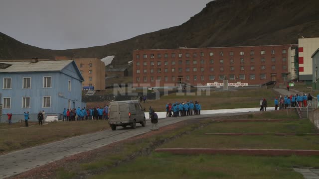 Tourists on the street in Barentsburg. Russian North, tourists, street, village, buildings.