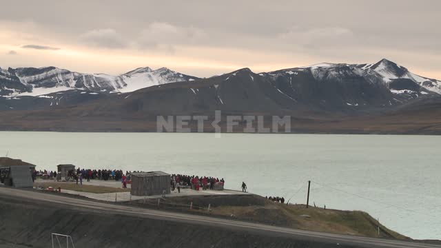 Views of snow-capped mountains and the sea, the people on shore. Russian North, shore, sea,...