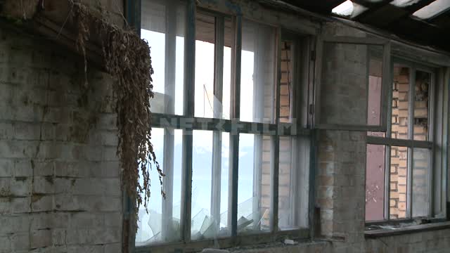 Помещение с выбитыми оконными стеклами в заброшенном здании. Русский север, комната, рамы, стекла,...