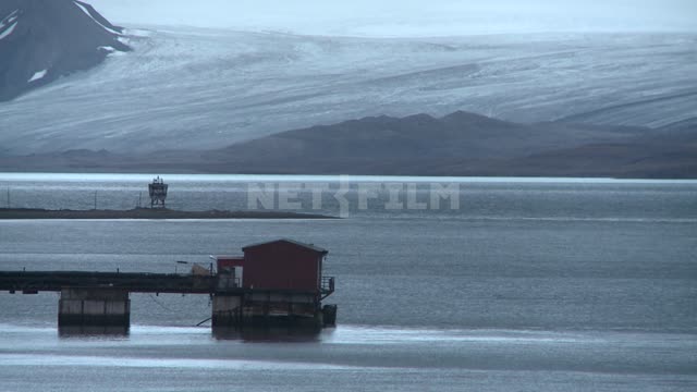 Berth of the seaport in Barentsburg.
 Russian North, Wharf, pier, sea, shore.