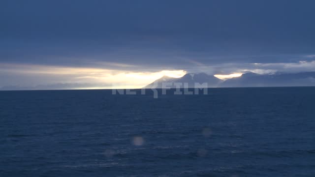 The view of the mountains from the sea. Russian North, mountains, sea, waves, sunset.
