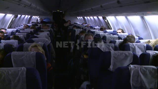 Салон самолета, пассажиры сидят в креслах. Русский север, самолет, пассажиры, рейс, салон, ночь,...