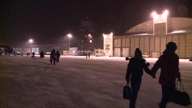 Пассажиры идут по летному полю в аэропорту. Русский север, ангар, самолет, аэропорт, ночь, зима,...