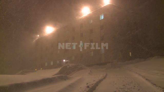 Вид на многоквартирный дом ночью в снегопад. Русский север, ночь, снег, метель, вьюга, буран,...