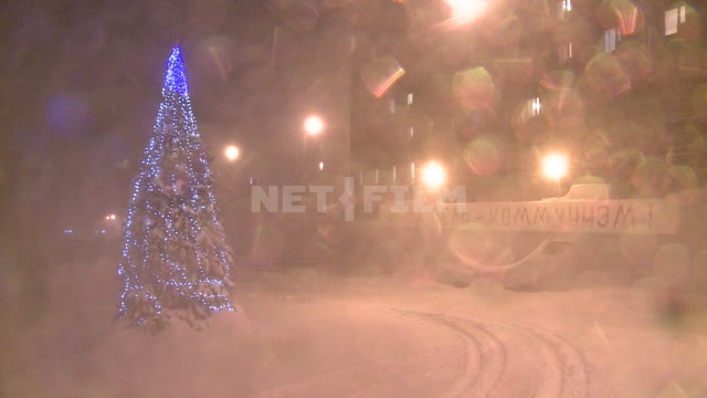 Новогодняя елка на площади в пургу. Русский север, елка, гирлянды, снег, пурга, буран, огни,...