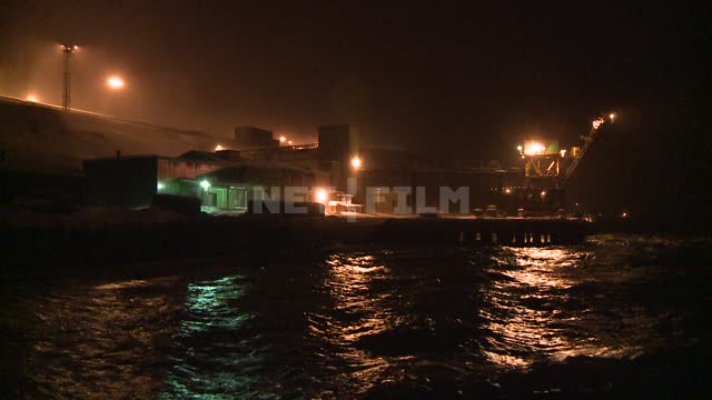 The view at night on the pier in the port city. Russian North, pier, sea, surf, wave, snow, night,...