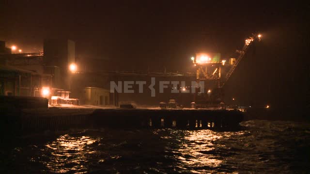 The view at night on the pier in the port city. Russian North, pier, sea, surf, wave, snow, night,...