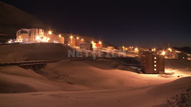 View of the lights in the buildings of the city of Barentsburg at night.
 Russian North,...