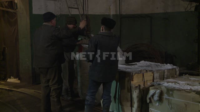 Workers install Packed goods on wooden pallet. Russian North, pallet, crane, cargo, worker.