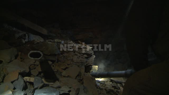 A miner breaks a rock with a jackhammer. Russian North, miner, mine, mine, helmet, flashlight,...