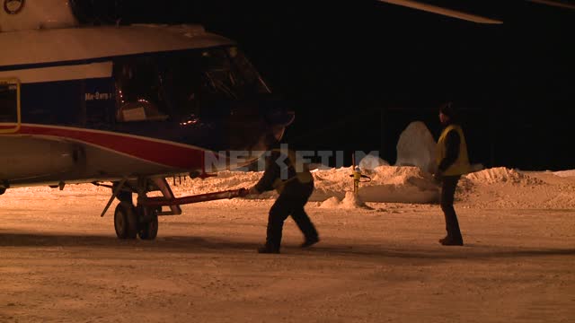 Towing the helicopter in the hangar Russian North, transport, helicopter, hangar, workers, night,...
