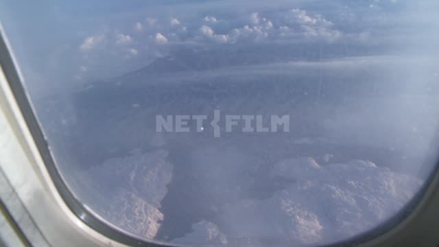 The view from the airplane window at the snowcapped mountains. Cloud.
The...
