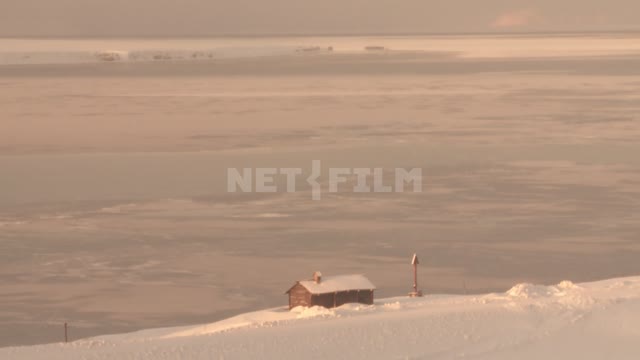 Заснеженный деревянный дом на берегу. Русский север
Дом 
Снег 
Лед.
Ясный день 
Снежные сугробы