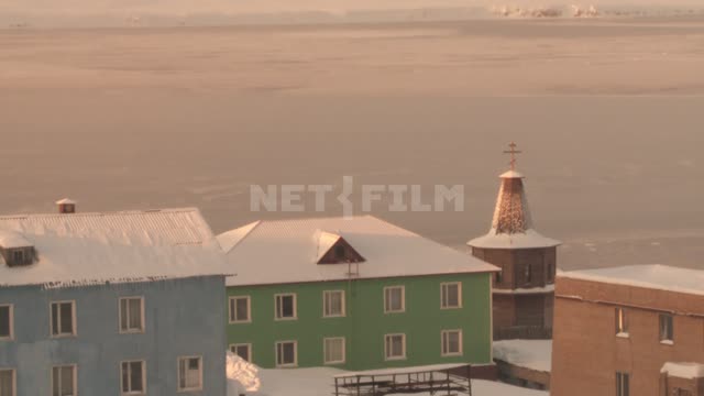Houses and wooden Russian Orthodox Church in the village. Russian North.
