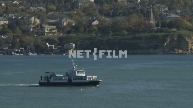 Boat sails on the background of residential buildings. Sevastopol....