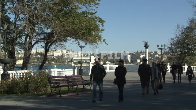 People are walking around Sevastopol's waterfront. Sevastopol.
People.
Day.
Quay.
Sea.
Trees.
Sunny...